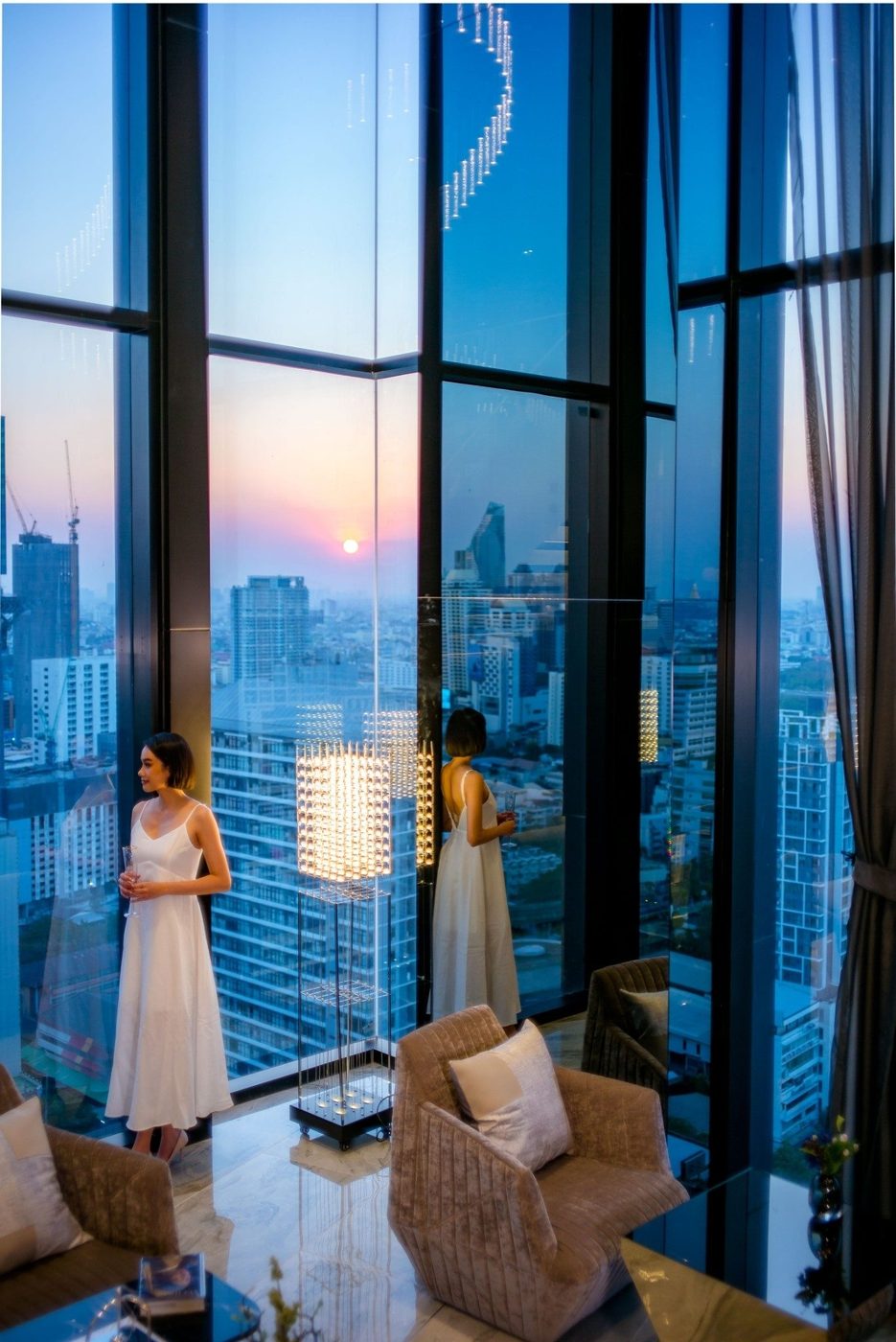 Park Origin Phayathai — lounge with floor-to-ceiling windows at sunset